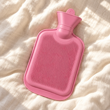 Hot Water Bottle - Pink 700mL resting on cream linen
