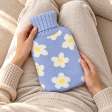 Hot Water Bottle with Cover - Blue Daisy 700mL resting on a clothed lap