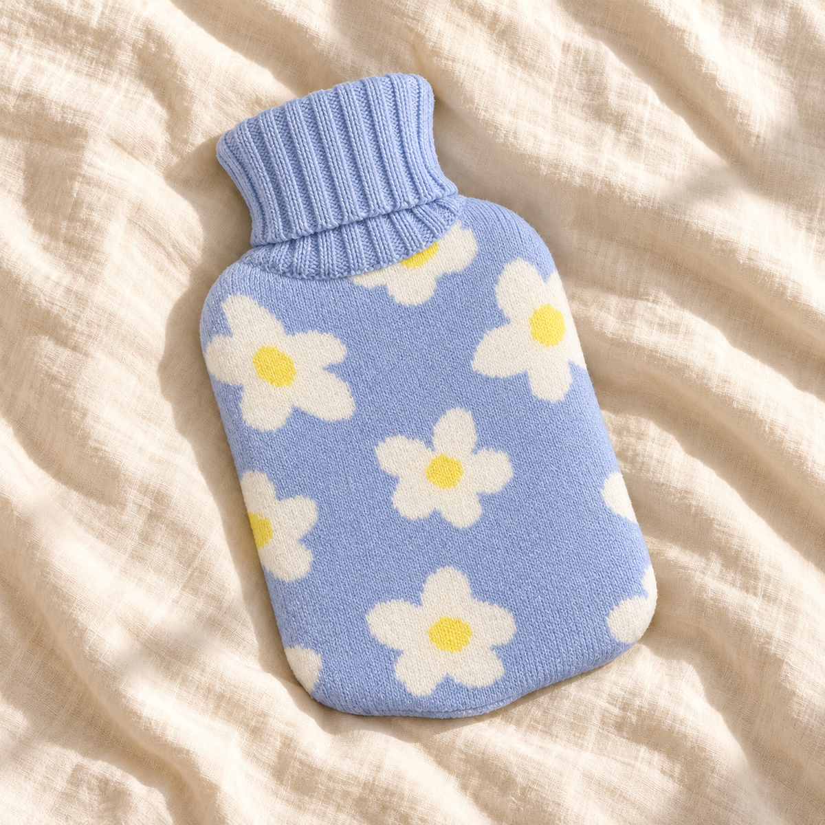 Hot Water Bottle with Cover - Blue Daisy 700mL lying flat on cream linen